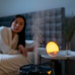 Девушка отдыхает в спальне рядом с работающим увлажнителем воздуха