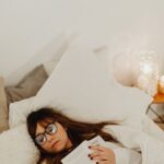 Женщина уснула в постели в очках и с книгой