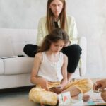 Папа с дочкой играют в настольную игру дома